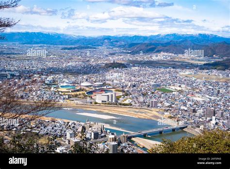 An Aerial View Of The Shinano River Flowing Through Gujo Cityscape In