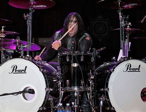 A Man With Long Hair Playing Drums On Stage