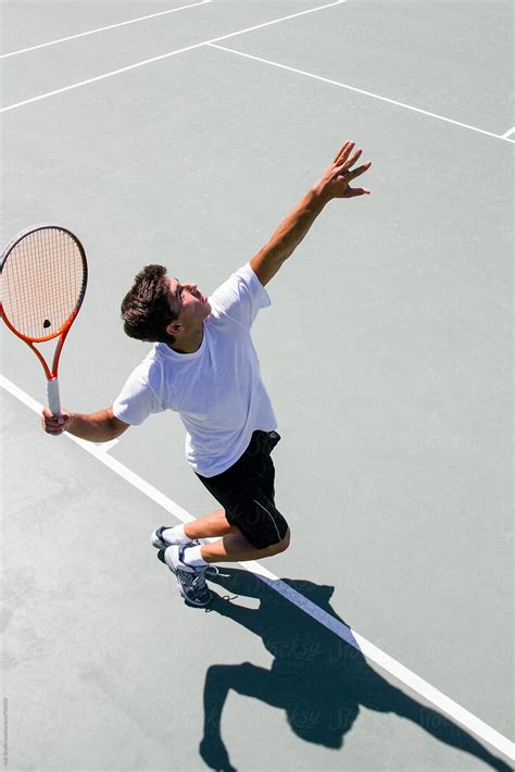 Tennis Player Serving In A Tennis Court Seen From Above By Stocksy