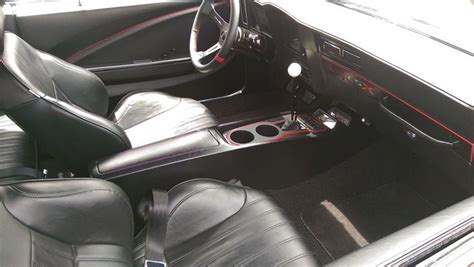 The Interior Of A Car With Black Leather And Red Stitching On The Dash