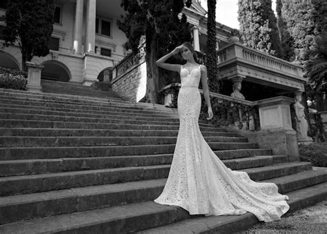 A Woman In A Wedding Dress Standing On Some Steps With Her Arms Behind