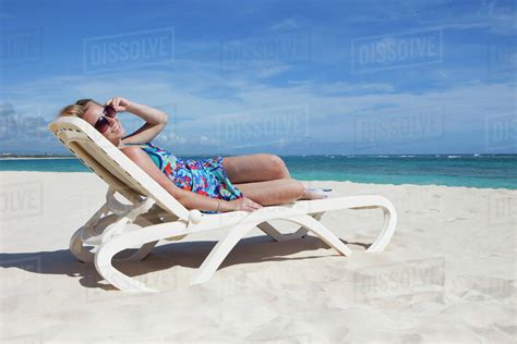A Woman Relaxing On A Beach Chair By The Ocean Punta Cana La