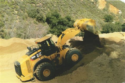 A Large Cat Wheel Loader Being Used To Pile Up Gold Decomposed Granite