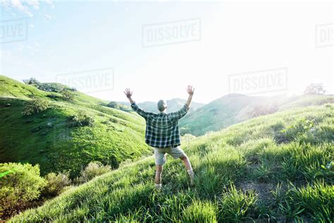 Older Caucasian Man Cheering On Rural Hillside Stock Photo Dissolve