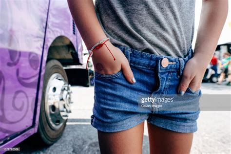 Midsection Of Girl Wearing Shorts Standing Outdoors Hands In Pockets