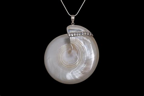 A Silvered White Large Mother Of Pearl Circular Shell Pendant On A