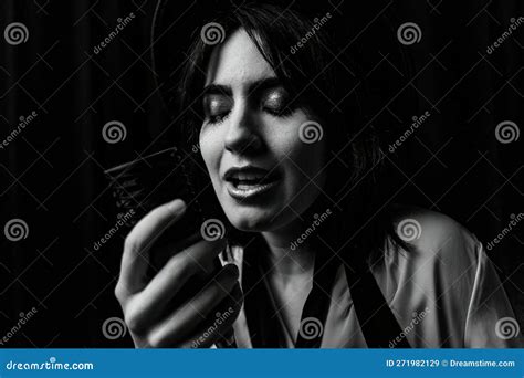 emotional close up black and white photo of brunette girl singing into vintage microphone stock