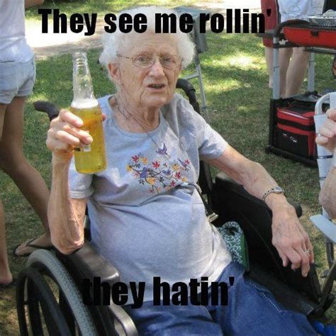 An Old Woman Sitting In A Wheel Chair Holding A Beer