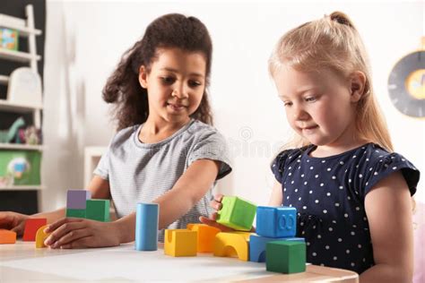 Cute Little Children Playing With Building Blocks In Kindergarten Stock