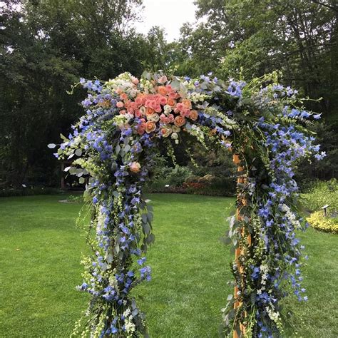 Ceremony site with flower arrangements and. Beautiful flowers cover arbor for wedding ceremony at ...