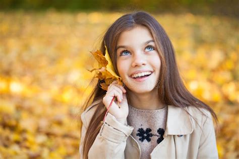 Portrait Of A Beautiful Brunette Little Girl Autumn Park Outdoors