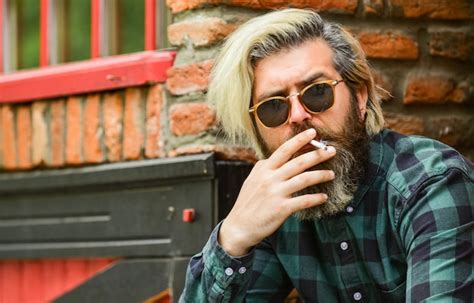 Hipster fumando fundo de arquitetura antiga cannabis médica óculos de sol brutais fumando tabaco