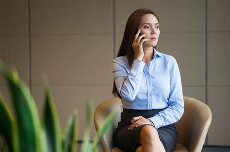 Serious Woman Talking on Phone in Office Lobby Photo | Free Download