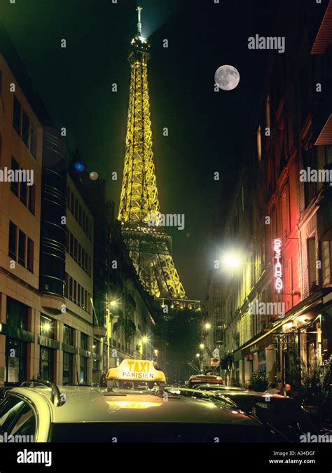 A View Of The Eiffel Tower From A Side Street With Parisien Taxi