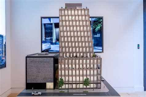 A Model Of A Tall Building In Front Of A Flat Screen Tv On A Wall