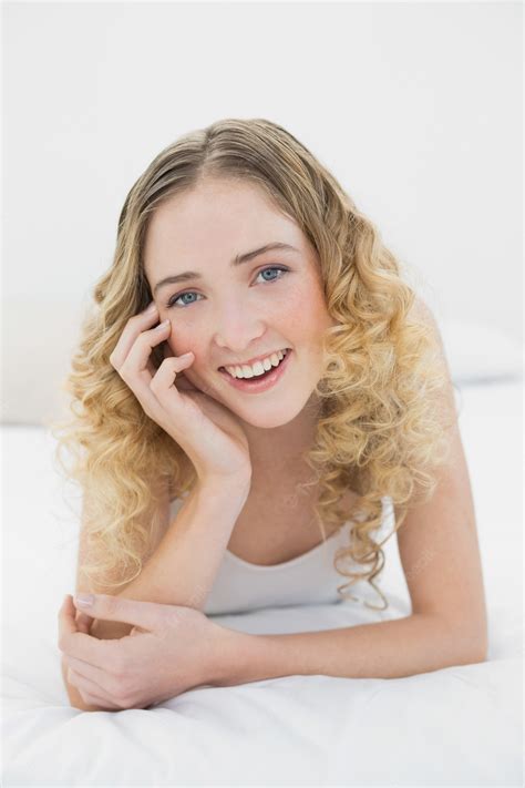 Premium Photo Pretty Smiling Blonde Lying On Bed Looking At Camera