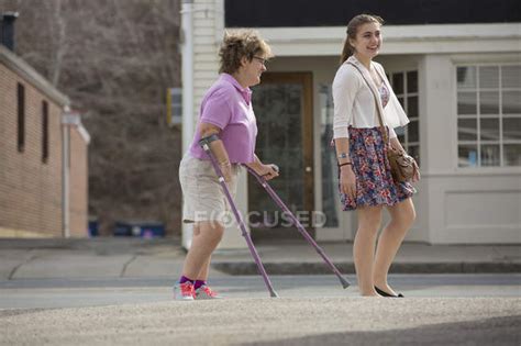 Woman With Cerebral Palsy And Crutches Walking With Her Sister In Town — Full Length People
