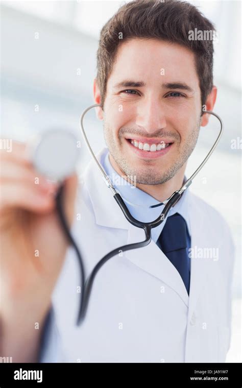 Happy Doctor With His Stethoscope Looking At Camera In Medical Office