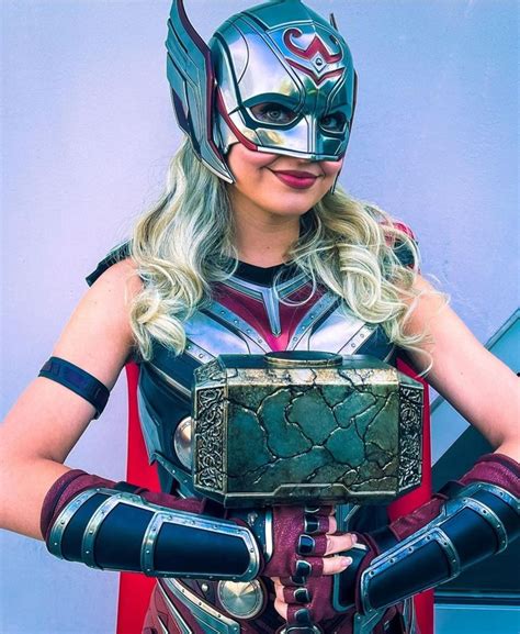 A Woman Dressed As Thor From The Avengers Movie Holding An Electronic