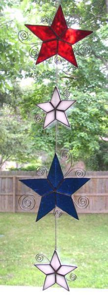 Three Red White And Blue Stars Are Hanging From A Wire In Front Of A Tree