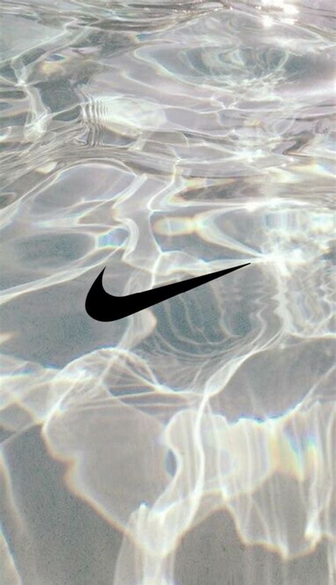 A Black Nike Logo Is Floating In The Clear Blue Water With Sunlight