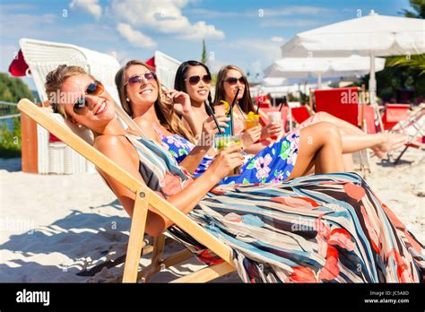Vier Frauen Am Strand Liege Bräunen In Der Sonne Liegen Stockfotografie Alamy