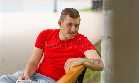 Portrait Of Young Man Sitting On Bench In Summertime Adult Male Poses While Resting In City