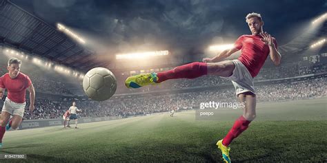 Soccer Player In Mid Air Volley Action During Football Match Photo