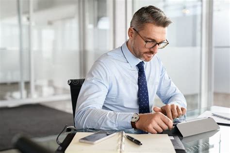 Mature Business Man Working On Digital Tablet In Office Stock Photo