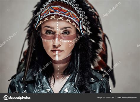 native american female model wearing conceptual aztec chief headdress and tribal make up in a