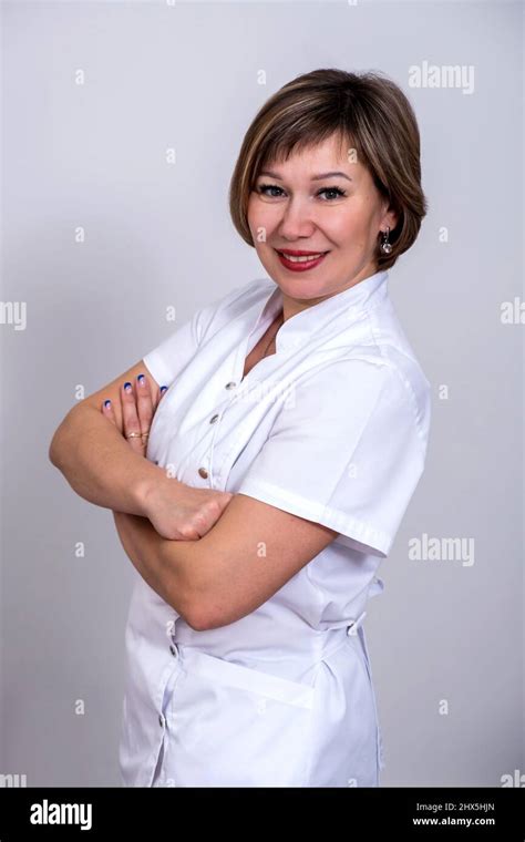 Nurse In A Medical Uniform Standing With Arms Crossed Looking At Camera And Wearing White