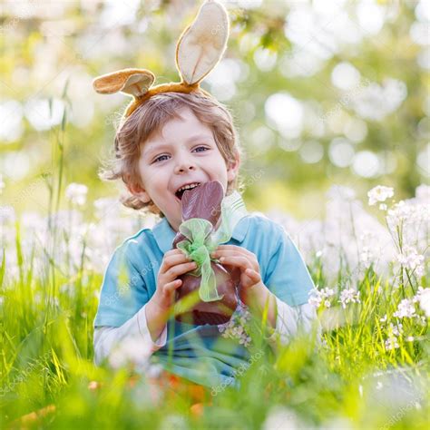 Little Toddler Wearing Easter Bunny Ears And Eating Chocolate At Stock