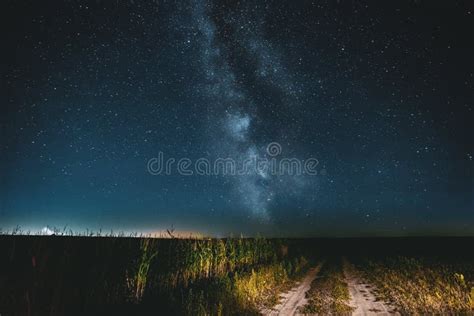 Night Starry Sky With Milky Way Glowing Stars Above Country Road Stock