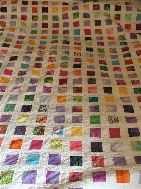 A Bed With A Colorful Quilt On Top Of It
