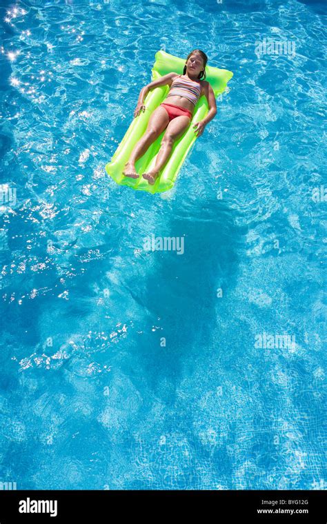 Girl Floating On Inflatable Raft In Swimming Pool Stock Photo Alamy