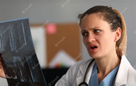 premium photo female doctor looks in amazement and shock at xray of spine