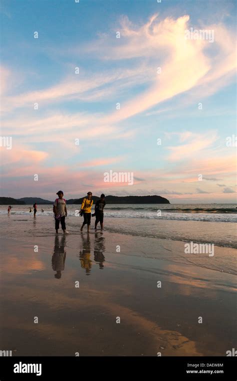 Thee Asian Tourists Walking On The Pantai Cenang Beach In Langkawi