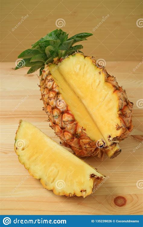 Piece Of Fresh Ripe Pineapple Cut From The Whole Fruit On Wooden Table