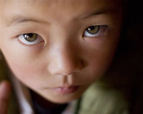 A Young Girl With Striking Green Eyes From Yuhu Village In Yunnan