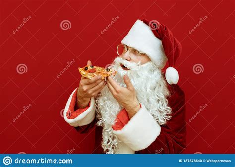Funny Santa Eating Delicious Pizza On Red Background And Looking Into