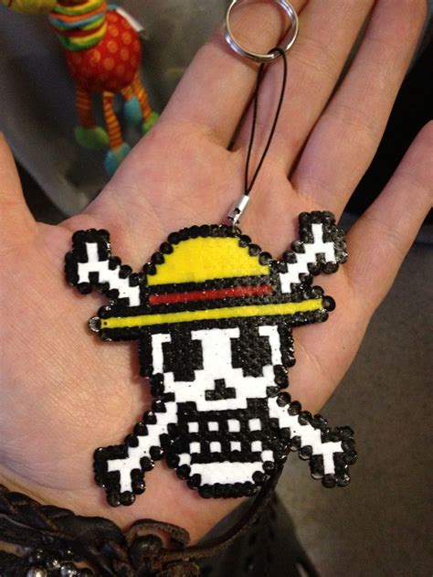 a hand holding a keychain with an image of a person wearing a hat