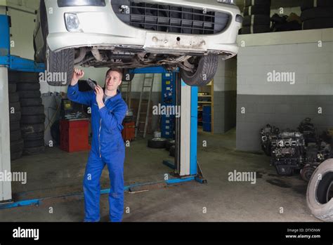 Mechanic Working Under Raised Car Stock Photo Alamy