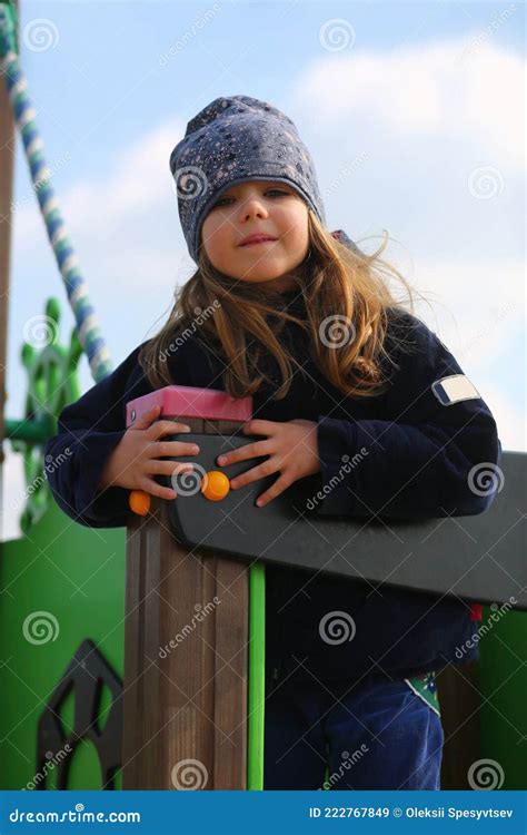Portrait Of A Caucasian Happy Girl Playing At Spring Outdoor Playground