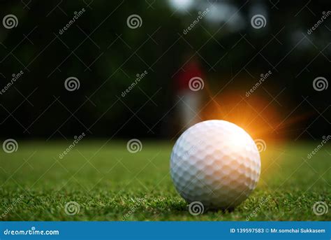 Blurred Golf Ball On Green In Beautiful Golf Course With Sunset Stock