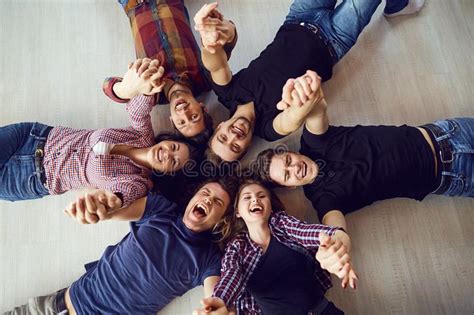 Top View A Group Of Friends Are Laughing Lying On The Floor Stock