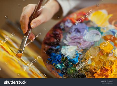 Artist Paints A Picture Of Oil Paint Brush In Hand With Palette Closeup