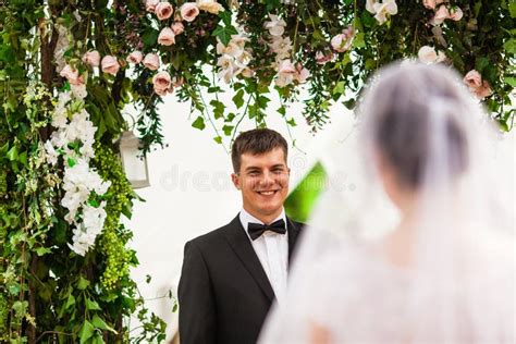 Wedding Couple Under The Flower Arch At The Wedding Ceremony Stock