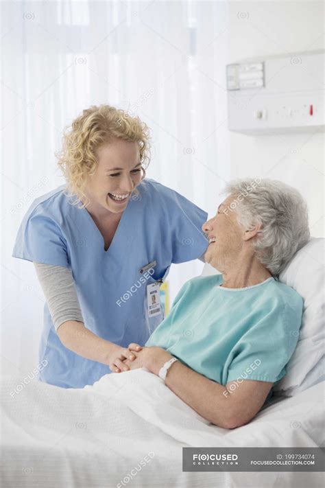 Nurse And Senior Patient Talking In Hospital Room — Trust Hospital