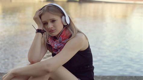 Lonely Girl Looking Very Sad While Listening Music Next To The Water