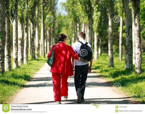 Mother And Child Walking Together In Summer City Park Stock Photo
